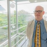 Benjamin Murphy in front of FSU Seal in the FSU Panama campus