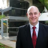 Carlos Guevara Mann standing in front of the FSU Panama main building