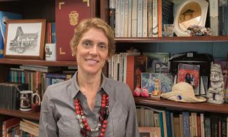 Alexandra Anyfanti standing in front of bookshelf